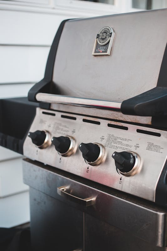 Stainless steel gas grill with four control knobs