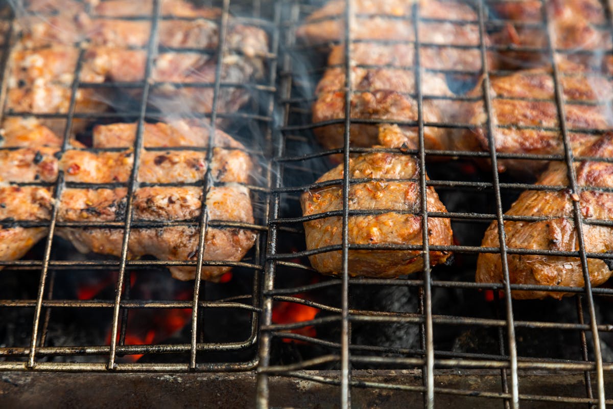 Succulent meat grilling on charcoal barbecue with smoky flavors
